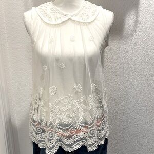 Sheer eyelet s/s blouse w/school girl collar, scalloped hem. One button close.